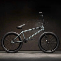Side view of Kink Whip 20 inch BMX bike in slate grey photographed in an industrial warehouse
