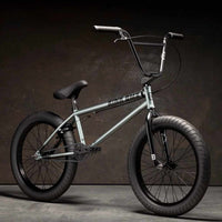 Kink Whip XL 20 inch BMX bike in slate grey photographed at a 45 degree angle in an industrial warehouse