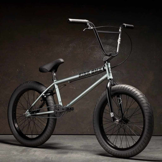 Kink Whip XL 20 inch BMX bike in slate grey photographed at a 45 degree angle in an industrial warehouse