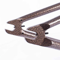 Close-up of a copper vein chain stay  with chain tensioners on a white background