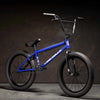 Kink Curb 20 inch BMX bike in Cobalt blue photographed at a 45 degree angle in an industrial warehouse