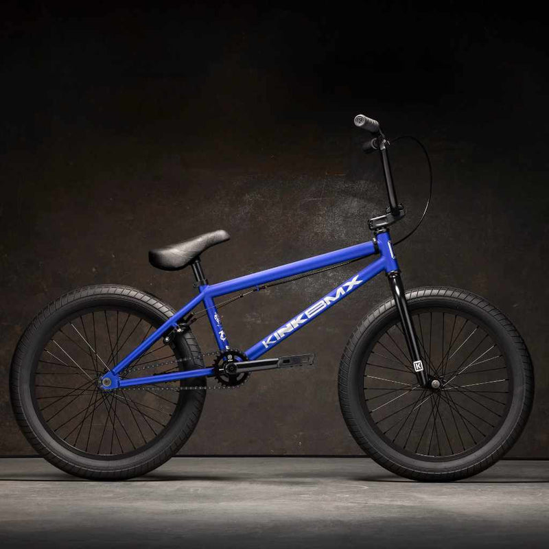 Kink Curb 20 inch BMX bike in Cobalt blue photographed from the side in an industrial warehouse