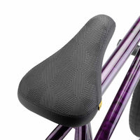 Close up of black Kink Impression Stealth Pivotal seat on a hazy purple Kink Downside BMX bike