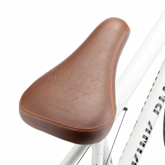 Close up of a brown Kink Plymouth/Bomber Stealth Pivotal seat on Terrazzo White Kink Gap BMX bike