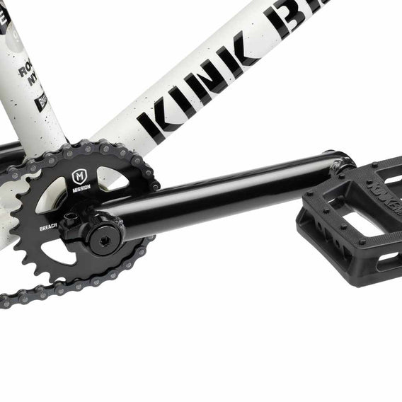 Close up of drive chain on Kink Gap BMX bike in Terrazzo White, photo shows Mission Breach 25 tooth sprocket, Kink Ridge Chromoly 3 piece cranks and Kink Hemlock plastic pedal