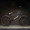 Side view of Kink Launch 20 inch BMX bike in midnight black photographed in an industrial warehouse