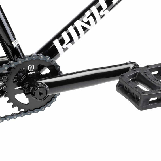 Close up of drive chain on Kink Launch BMX bike in marble black, photo shows Mission Breach 25 tooth sprocket, Mission Triumph Chromoly 3 piece cranks and Kink Hemlock plastic pedal