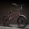 Kink Launch 20 inch BMX bike in plasma red photographed at a 45 degree angle in an industrial warehouse