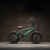 Kink Pump 14" BMX bike in Green side view, photographed in an industrial warehouse