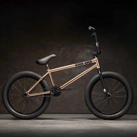 Side view of Kink Williams 20 inch BMX bike in mojave bronze photographed in an industrial warehouse