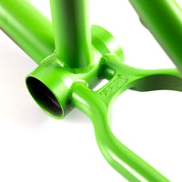 Close-up of a green CULT AK BMX frame bottom bracket shell and invest cast wishbone on a white background 