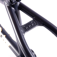 Close-up of a navy blue bicycle frame with a brand logo on a white background