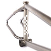 Close-up of a metallic bicycle frame with checkered pattern on a white background