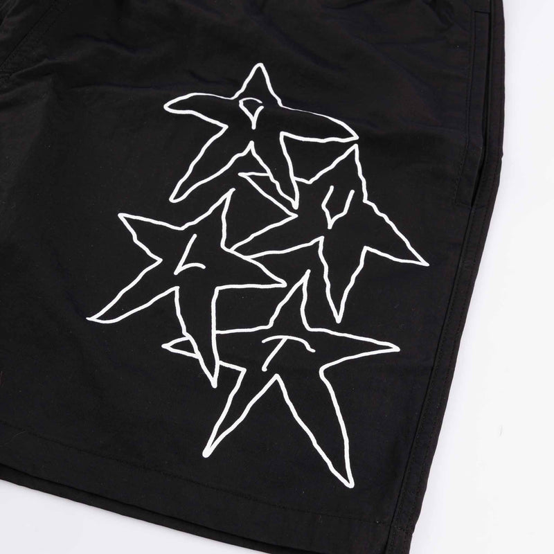 Black shorts with white star designs on a white background