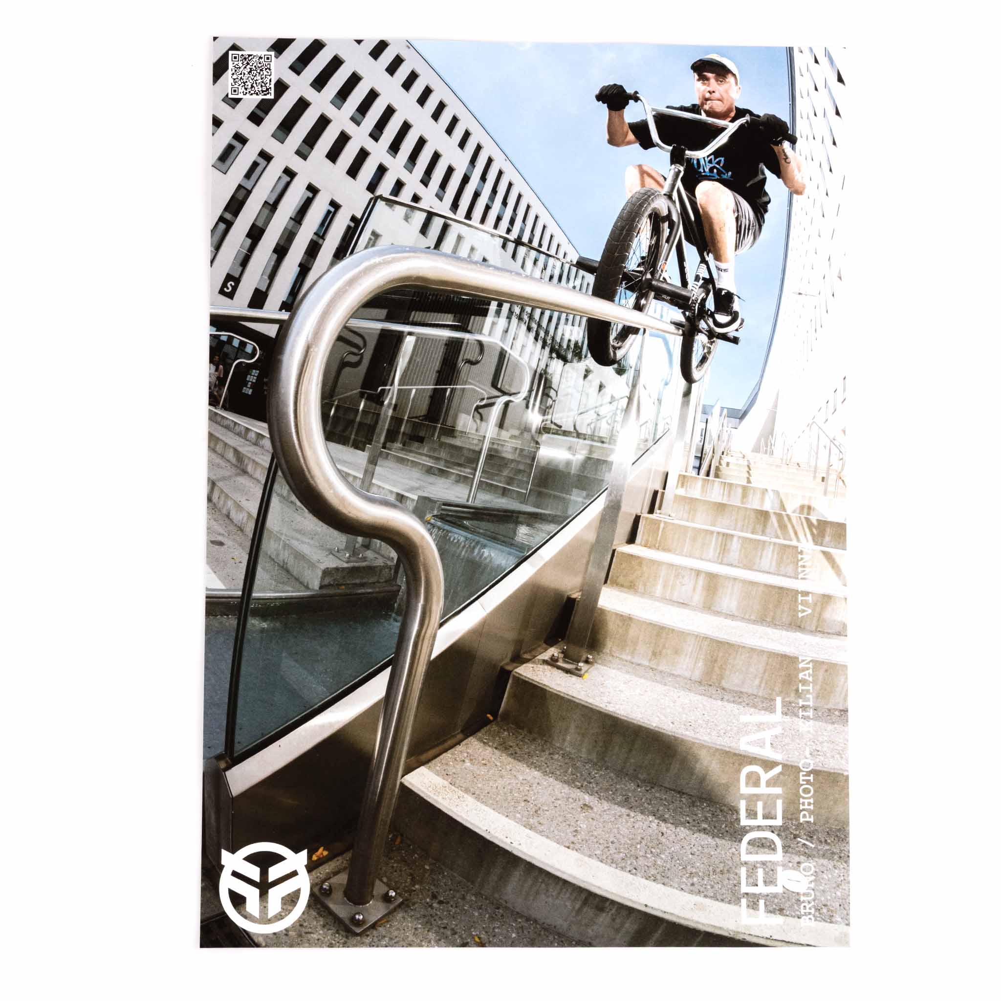 Person riding a bicycle on a staircase with modern architecture in the background