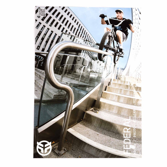 Person riding a bicycle on a staircase with modern architecture in the background
