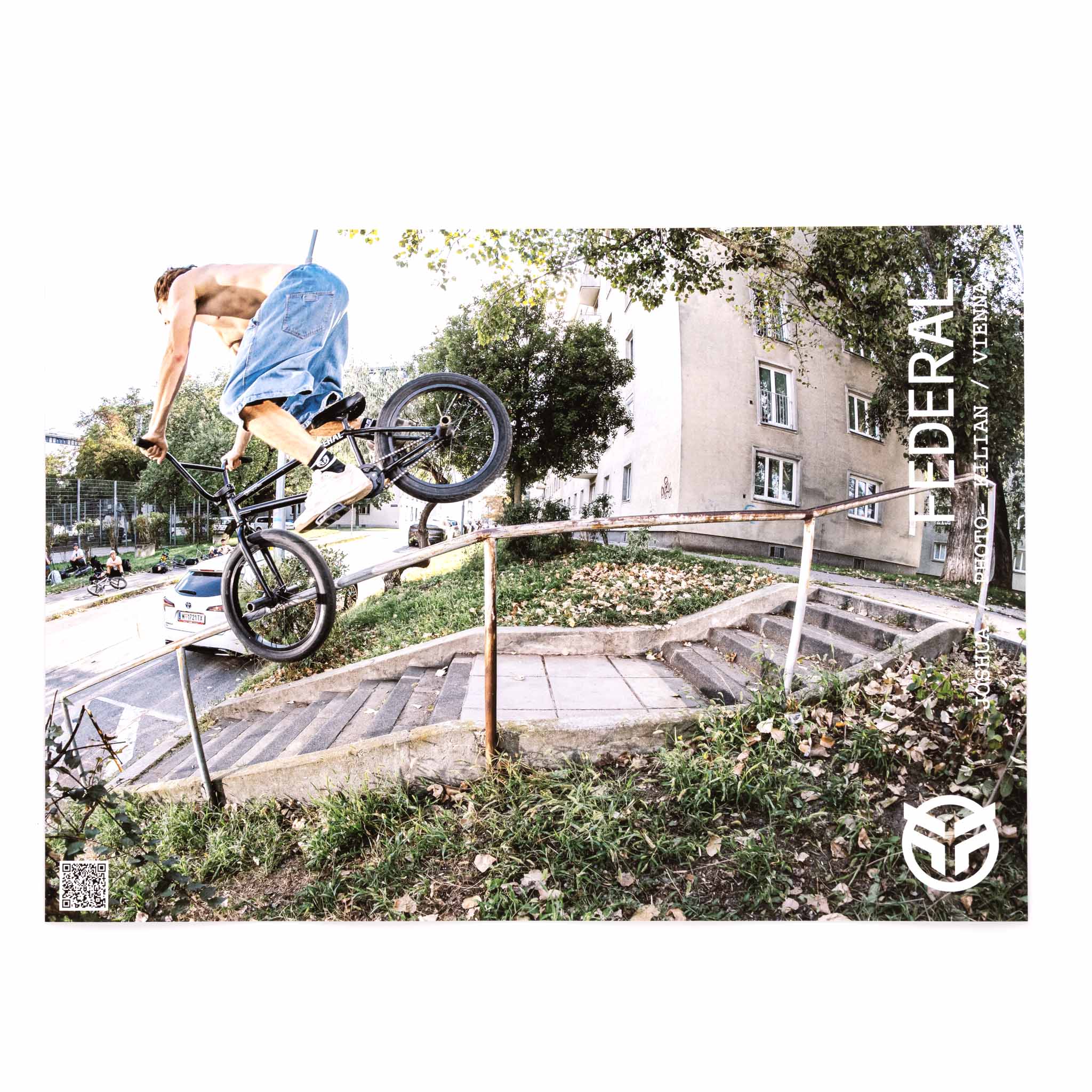 Person performing a bike trick on a railing in an urban setting with 'Federal' branding.
