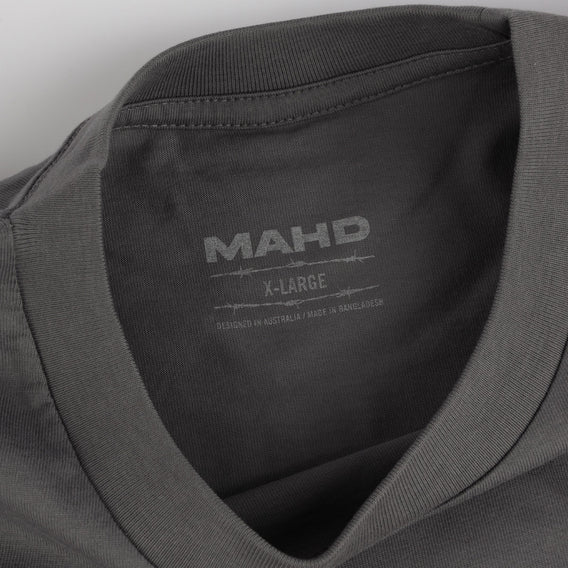 Close-up of a gray shirt with 'MAHD' branding and size label.
