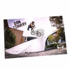 Biker performing a trick on a ramp with 'Dan Conway' and 'Profile Racing' branding.