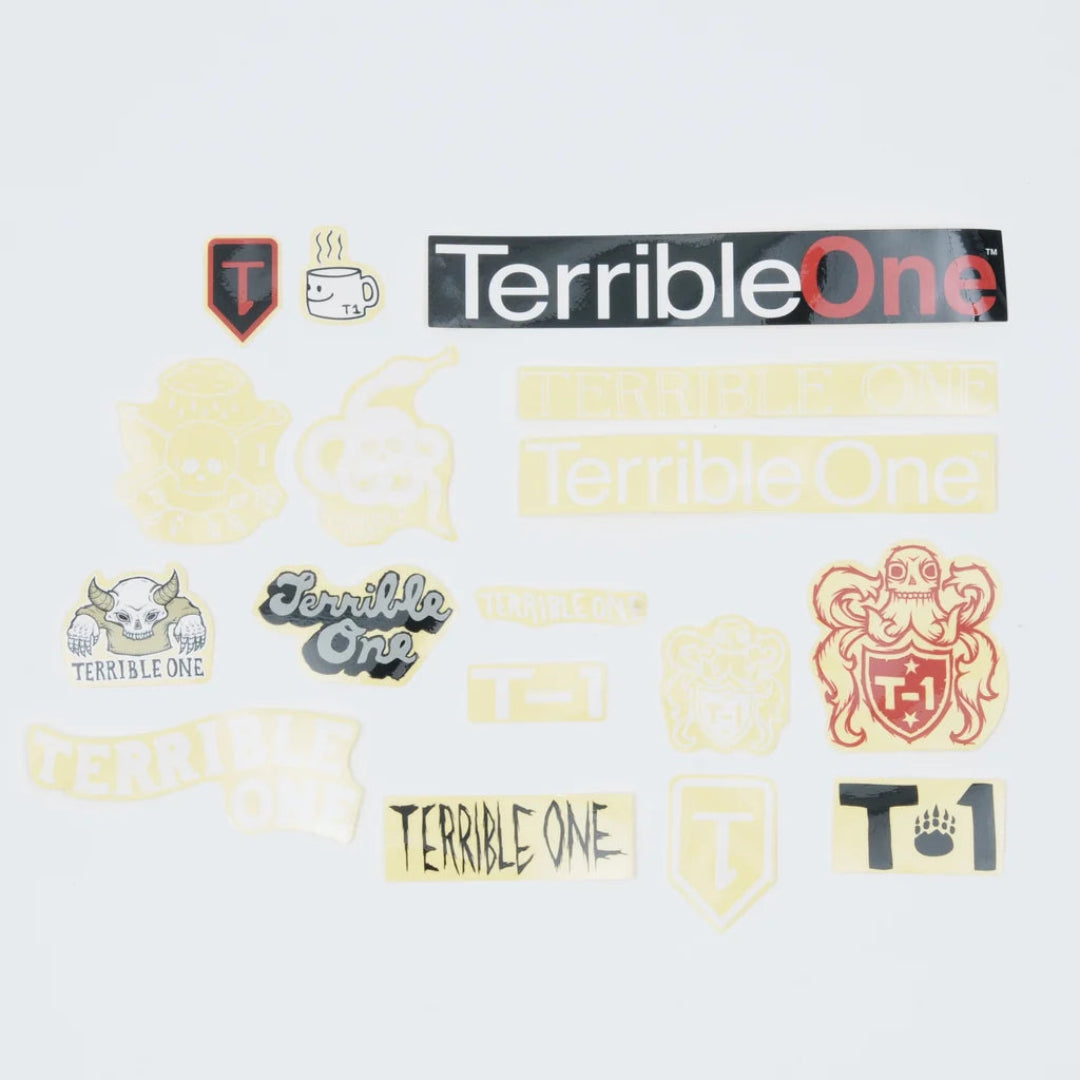 A collection of various 'Terrible One' themed stickers and decals displayed on a light gray background, including a large black and red logo sticker, a skull crest, a coffee cup, and several smaller graphic designs.