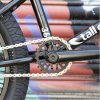 Close-up of a bicycle chain and sprocket with a colorful background