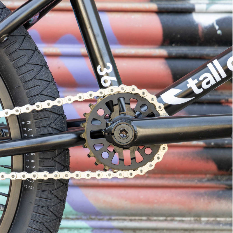 Close-up of a bicycle chain and sprocket with a colorful background