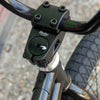 Close-up of a bicycle handlebar with 'Shadow Conspiracy' branding on a blurred background.