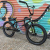 Black BMX bike in front of a colorful graffiti wall