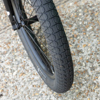 Close-up of a bmx subrosa matt real designer tire with tread pattern on a gravel surface