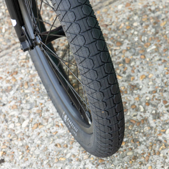 Close-up of a bmx subrosa matt real designer tire with tread pattern on a gravel surface