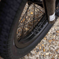 Close-up of a cult bmx wheel on a textured pavement surface