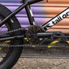 Close-up of a BMX chain and gear system with 'Tall Order' branding.