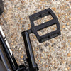 Close-up of a black federal bmx bicycle pedal on a gravel surface