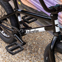 Close-up of a tall order 16 BMX bike with branding on a textured surface.