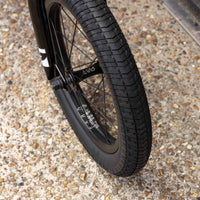 Close-up of a bicycle wheel on a textured pavement surface