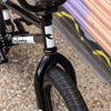 Close-up of a black tall order bmx frame with visible branding on a blurred background