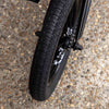 Close-up of a black bmx tyre on a textured pavement surface